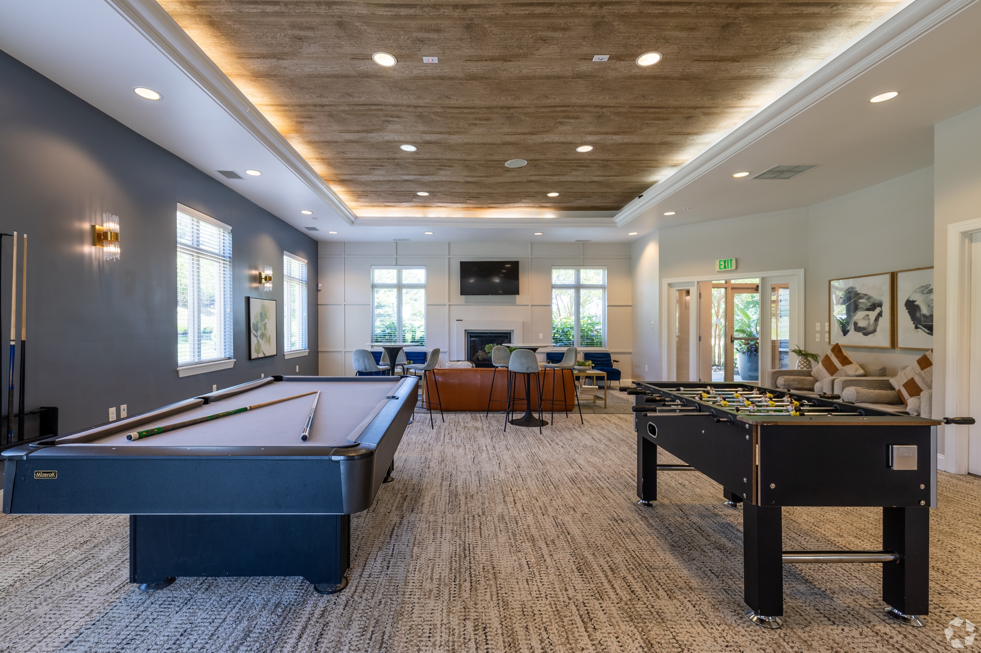 Clubhouse at ReNew White Marsh with dining table, kitchen with barstools, pool table, and foosball table