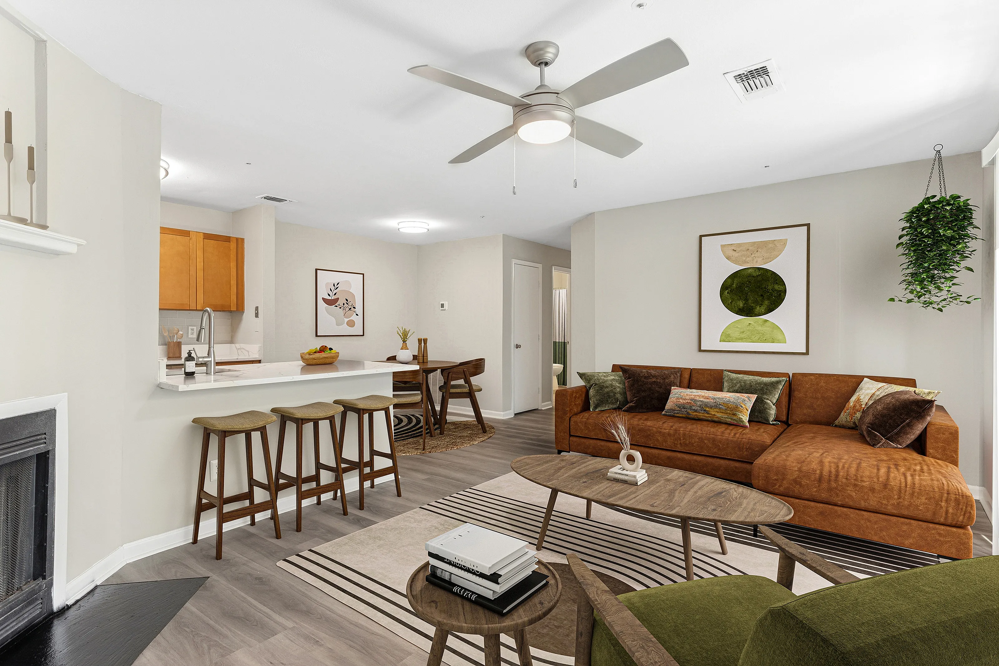 Modern living area with open kitchen, cozy brown sectional, and stylish decor, featuring natural wood and greenery accents.