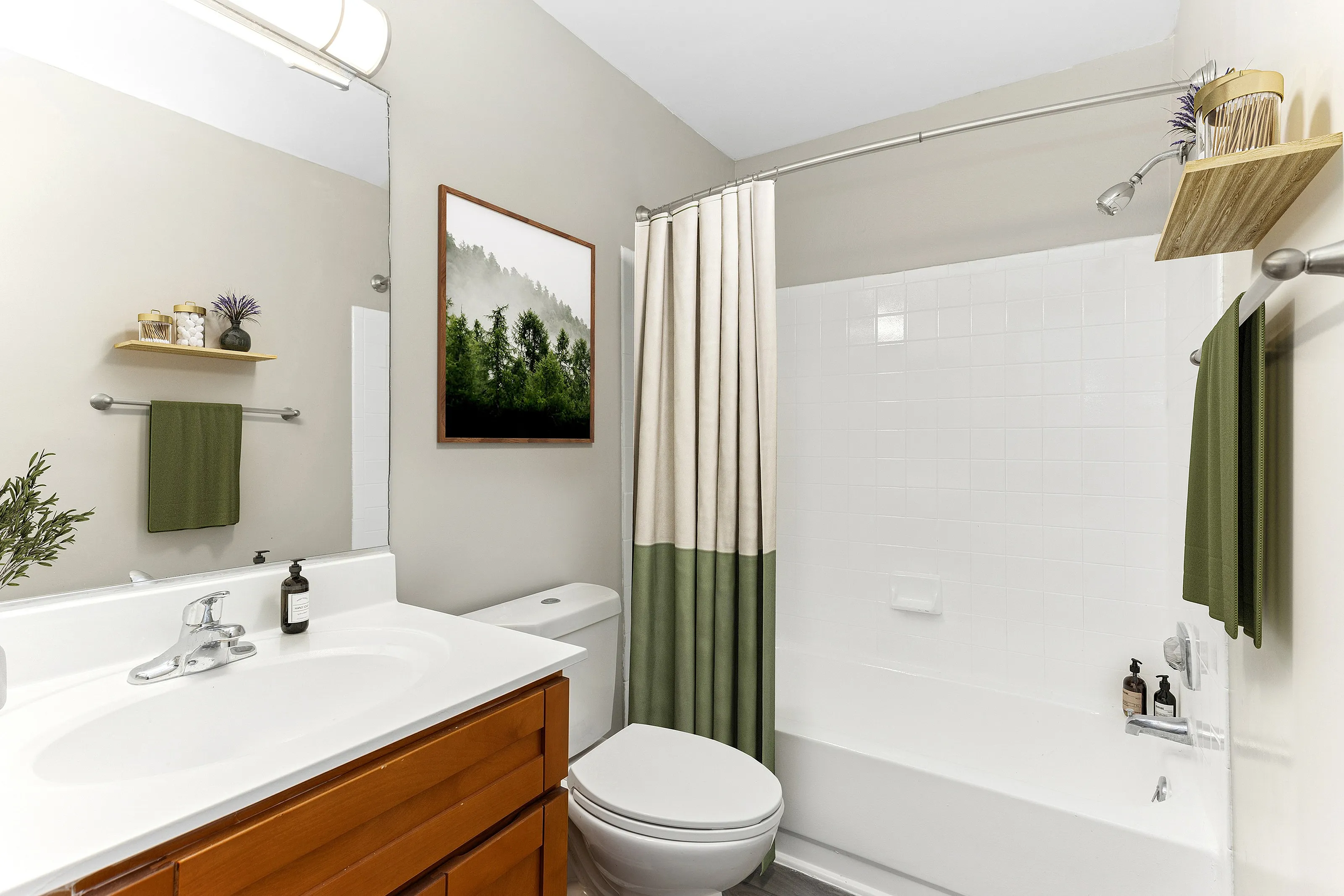 Elegant bathroom with modern fixtures, wooden cabinetry, and greenery accents for a serene atmosphere.