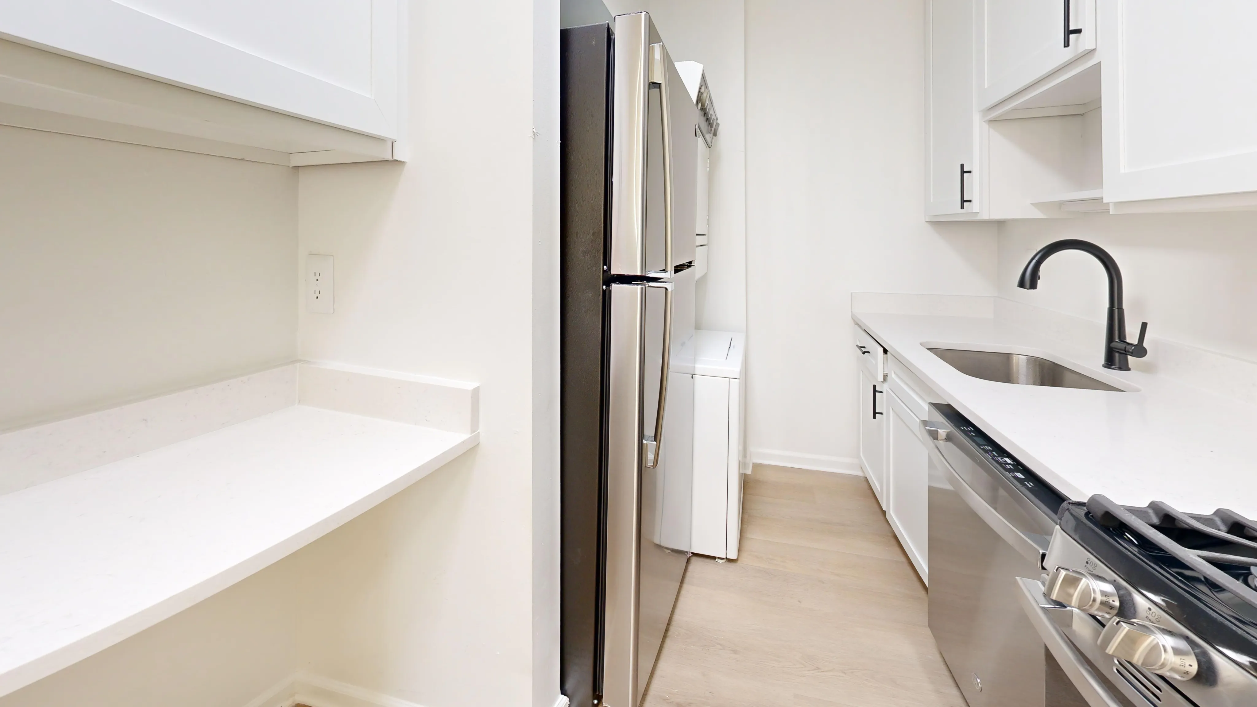 Sleek modern kitchen featuring stainless steel appliances, elegant white cabinetry, and a stylish black faucet.