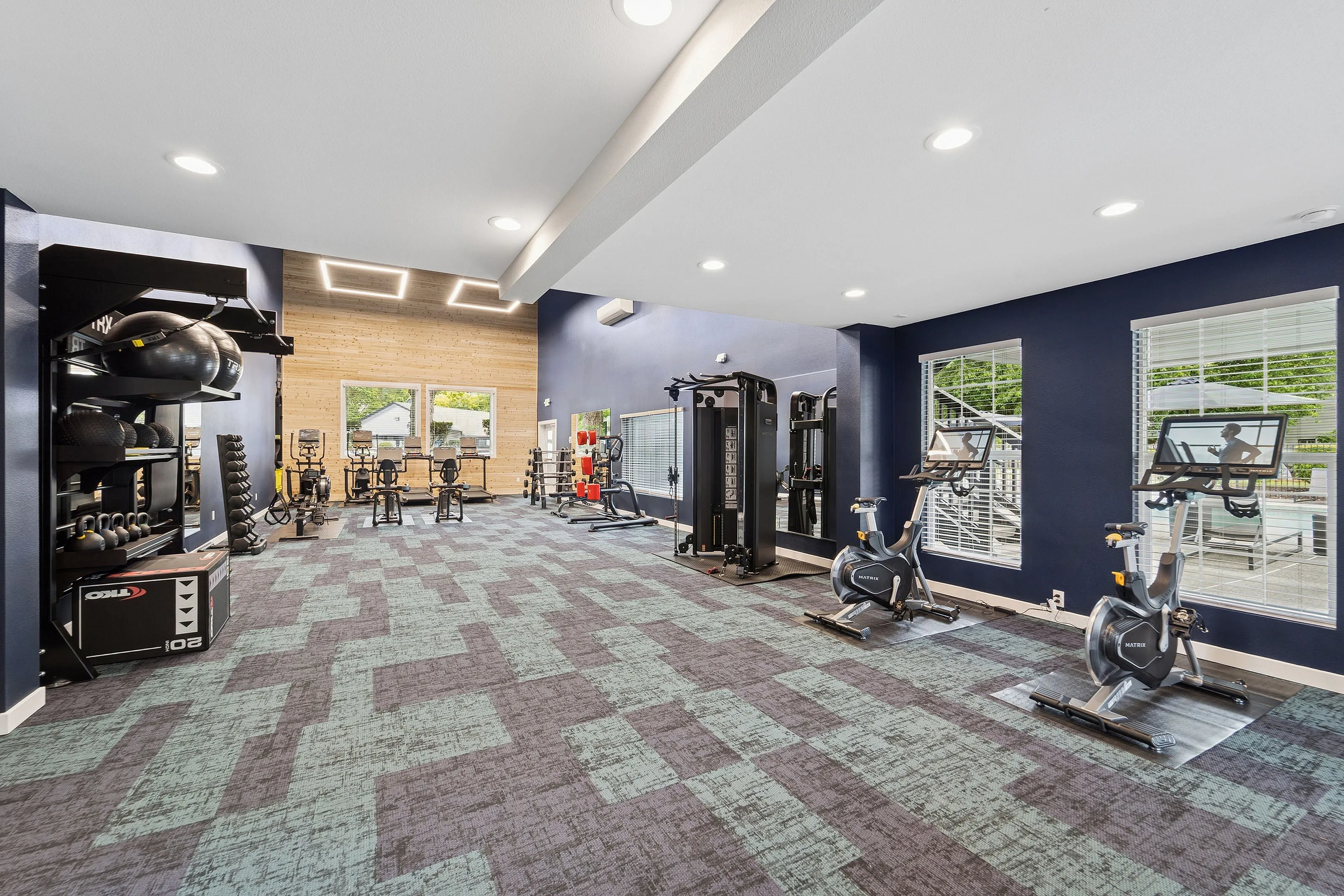 Contemporary fitness center with modern equipment, natural light, and vibrant decor.