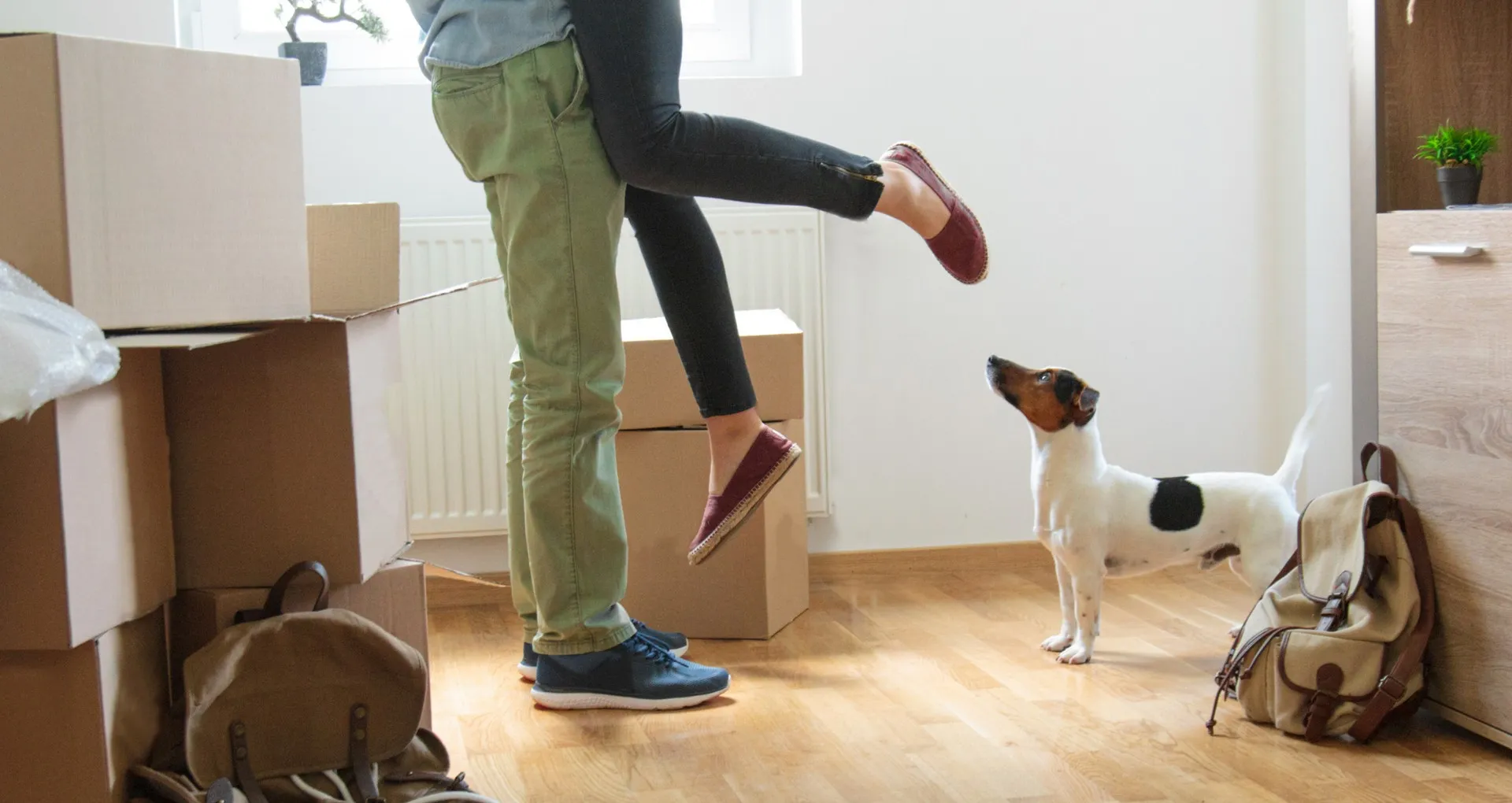 Happy man lifting woman in new house