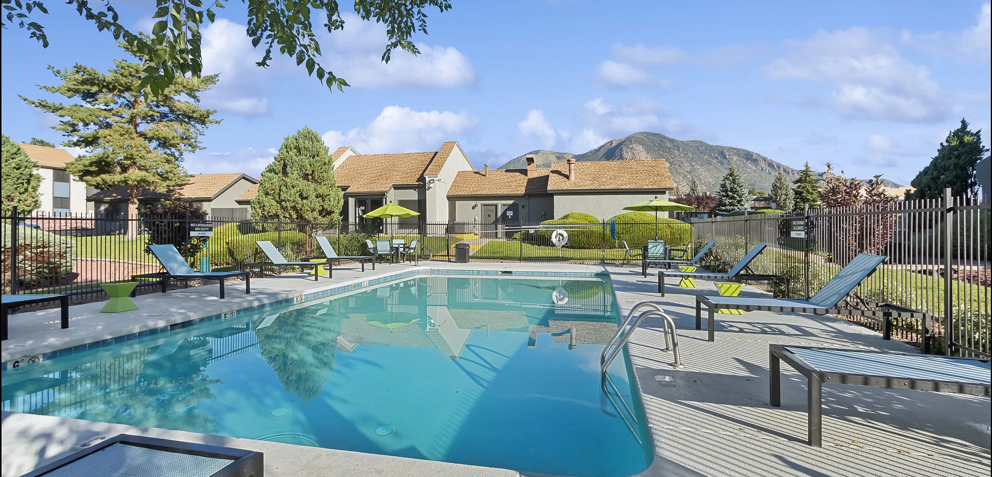 Inviting outdoor pool area with lounge chairs, set against scenic mountain views.