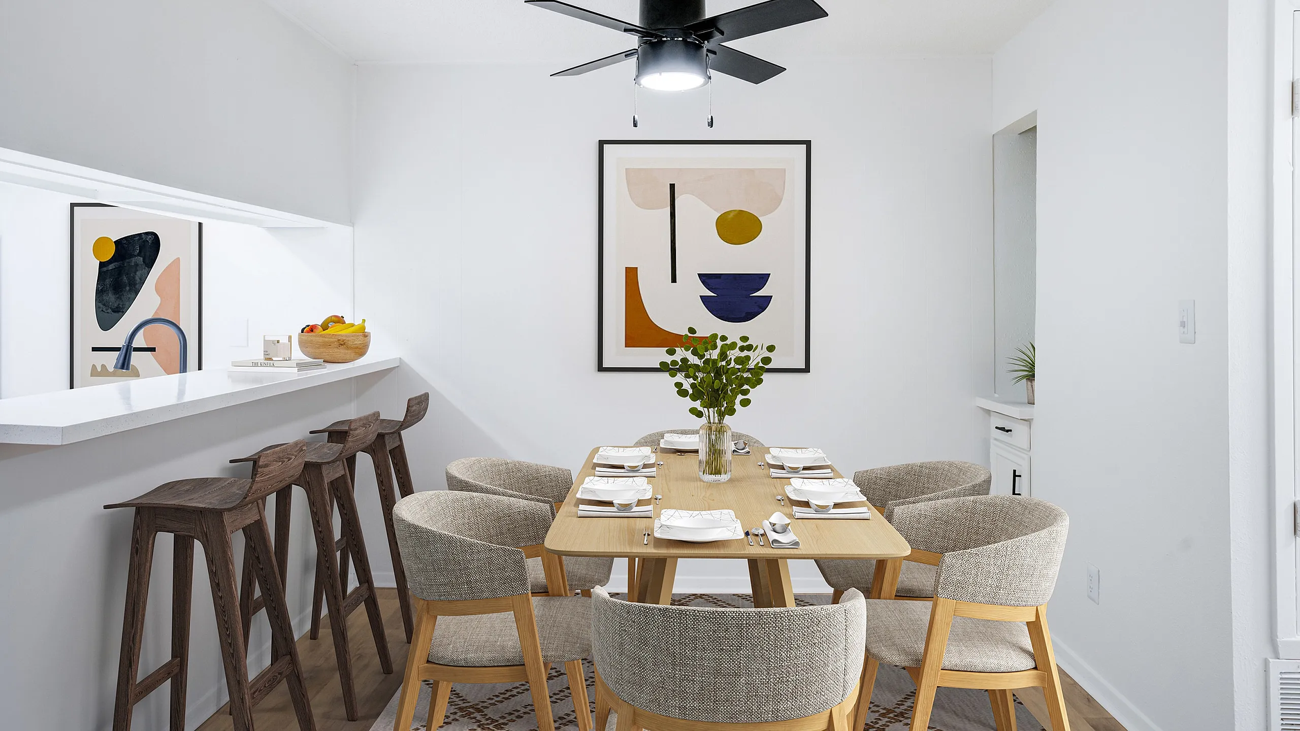 Contemporary dining area featuring a sleek wooden table set for six, modern bar stools, and stylish art decor, perfect for elegant gatherings.