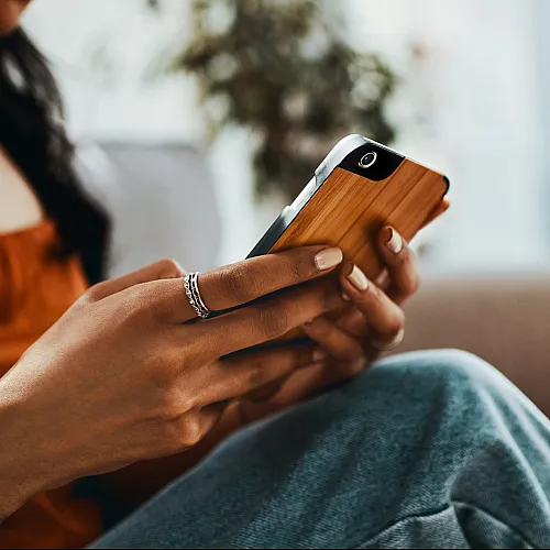 Modern cozy living space with a person using a smartphone while relaxing on a comfortable sofa.