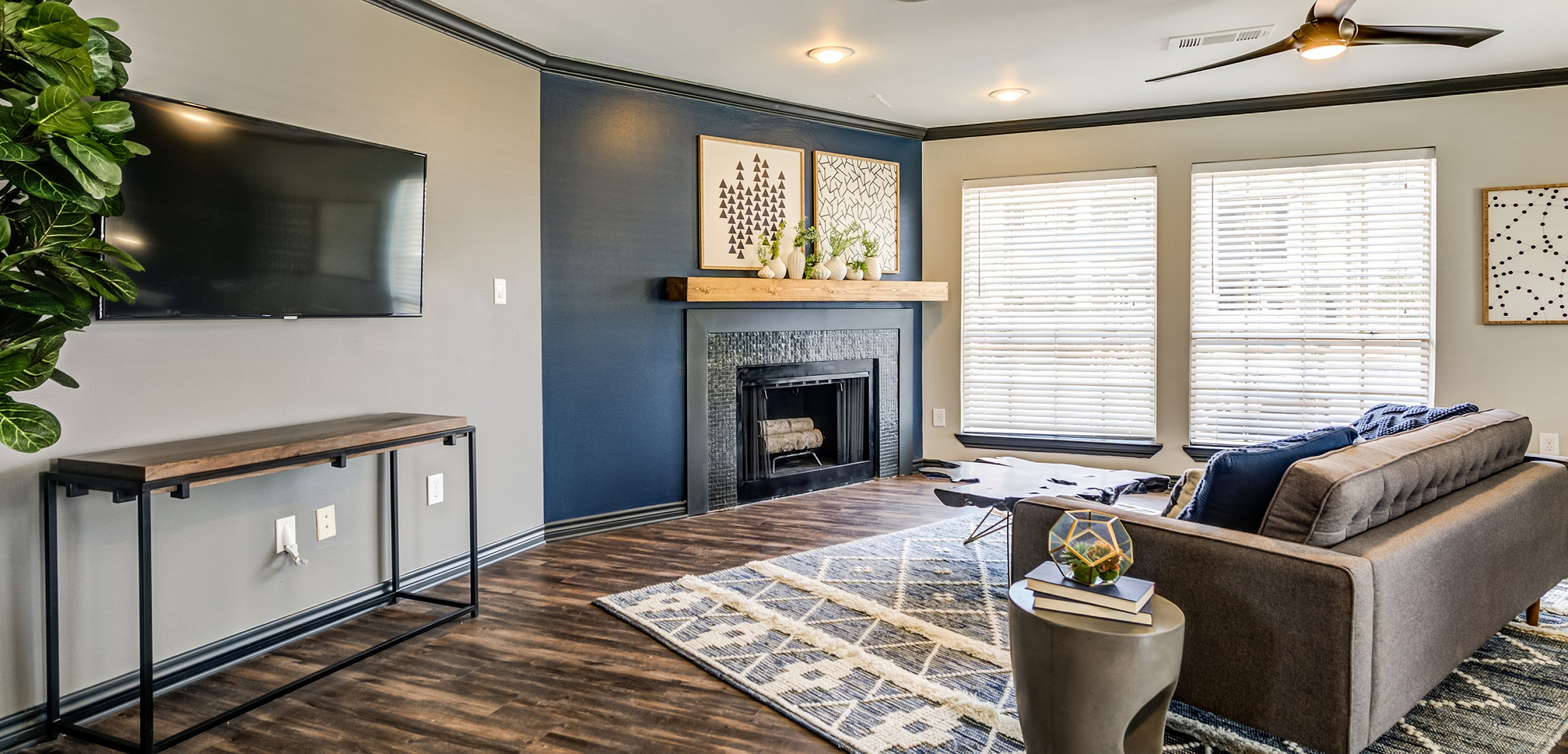 Chic living room with elegant hardwood floors, modern fireplace, large windows, and stylish decor.