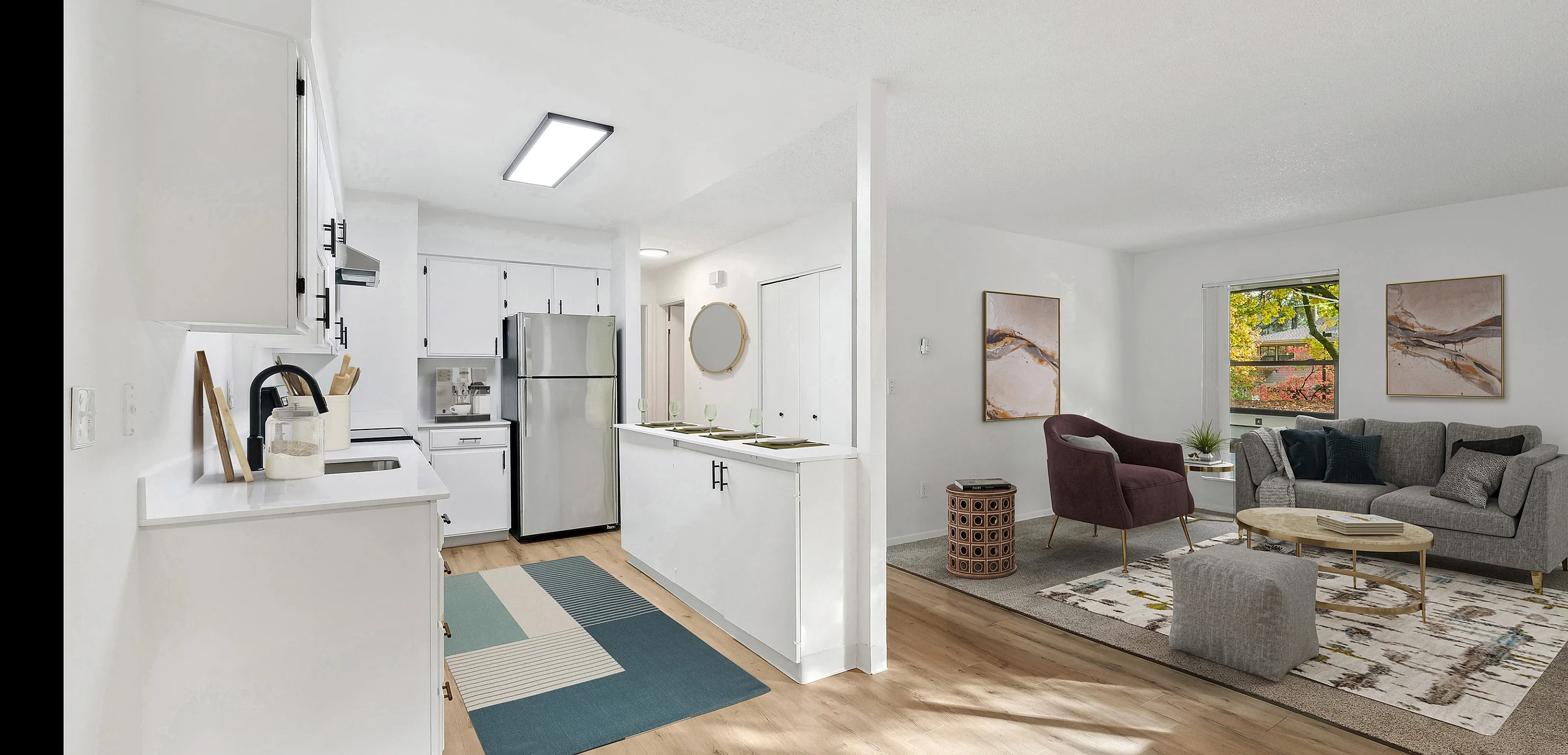 Bright and inviting open-concept apartment featuring a modern kitchen with stainless steel appliances and a cozy living area with stylish decor.