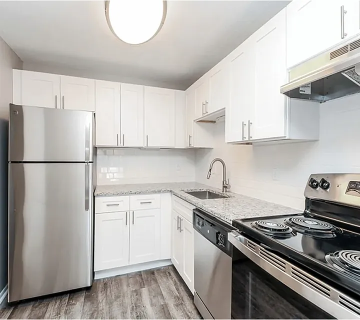Modern kitchen with sleek stainless steel appliances, stylish white cabinetry, and elegant granite countertops.