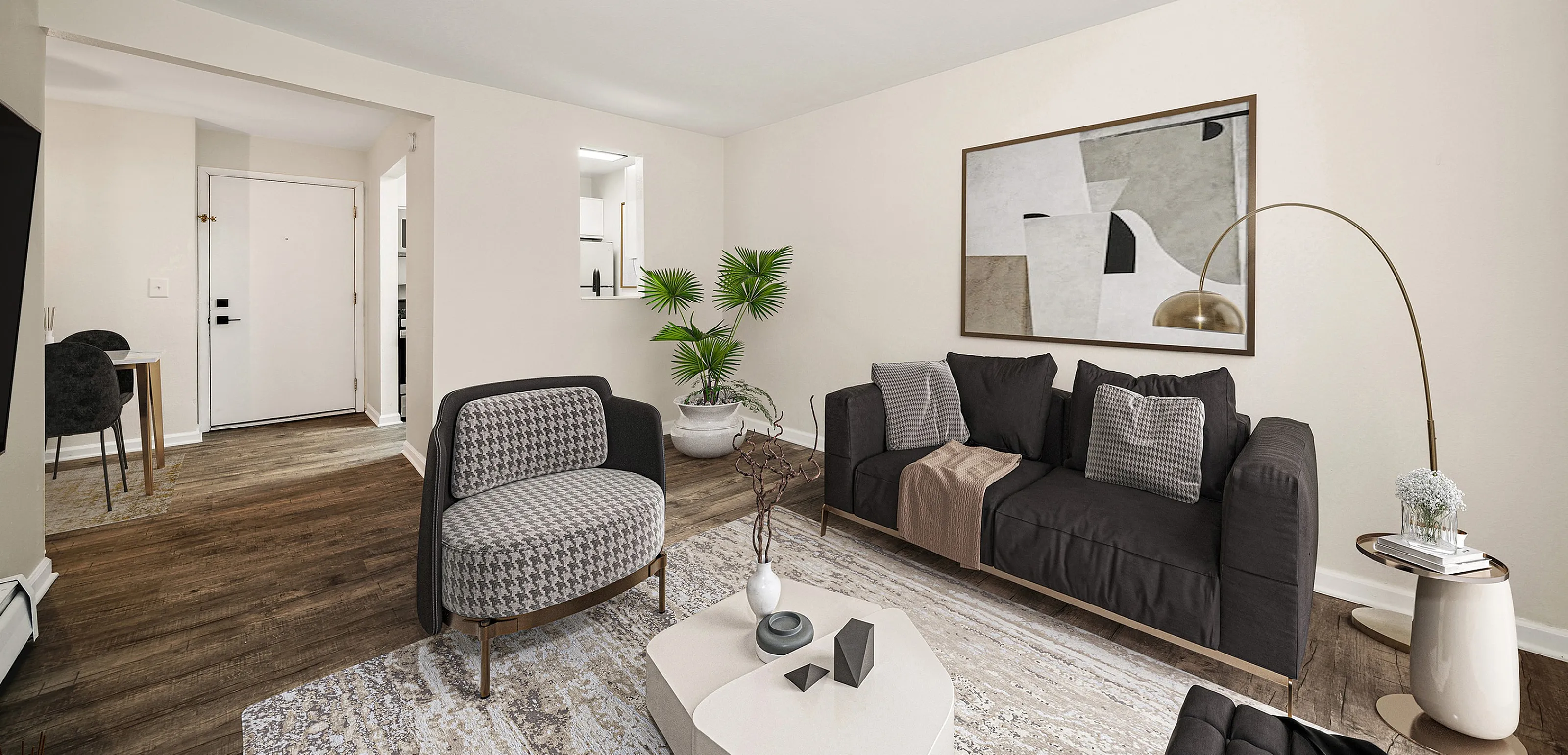 Chic living room featuring stylish seating, modern art, and warm decor, complemented by a welcoming entrance and elegant flooring.