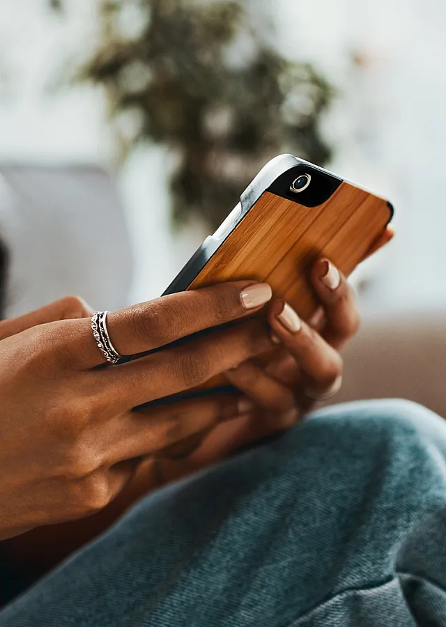 Cozy interior scene with a person using a smartphone, relaxing on a comfortable sofa in a stylish modern apartment.