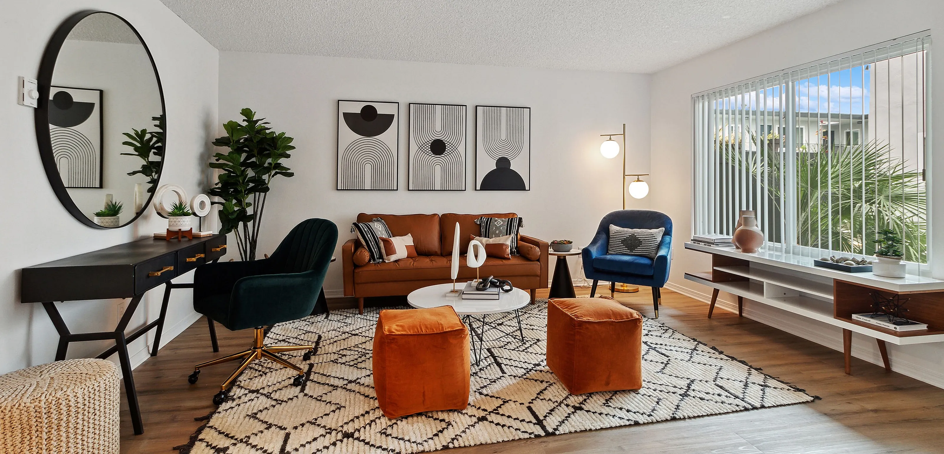 Chic living room with modern decor, featuring stylish seating, vibrant orange ottomans, and a large window with natural light.
