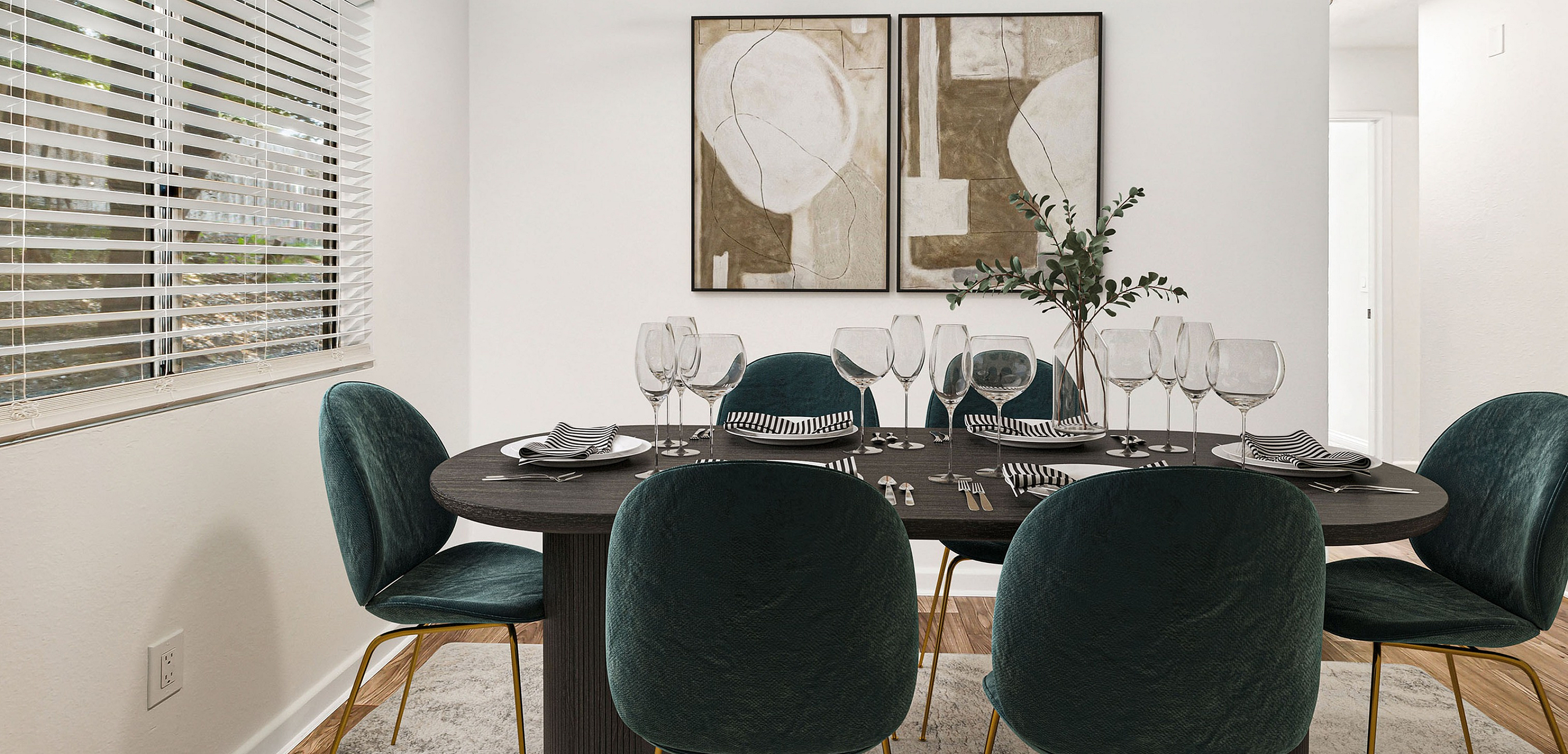 Elegant dining area with a modern table set for six, featuring plush teal chairs, abstract wall art, and abundant natural light through large windows.