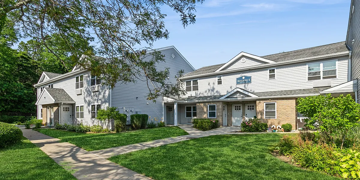 Charming townhouse complex surrounded by lush greenery and well-maintained pathways, offering a serene and inviting atmosphere.