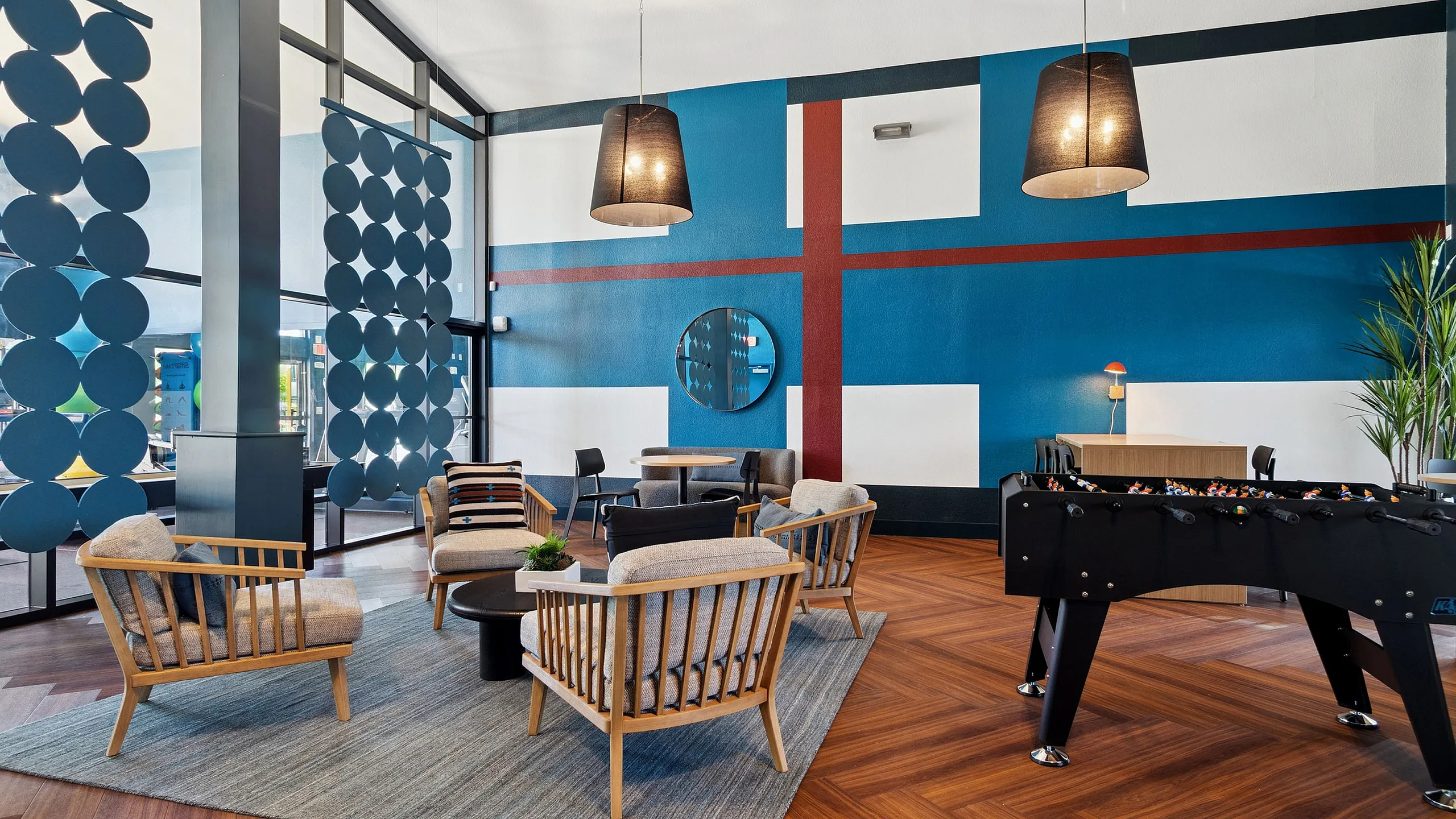 Chic apartment lounge with modern decor, stylish seating, and a foosball table, perfect for relaxation and entertainment.