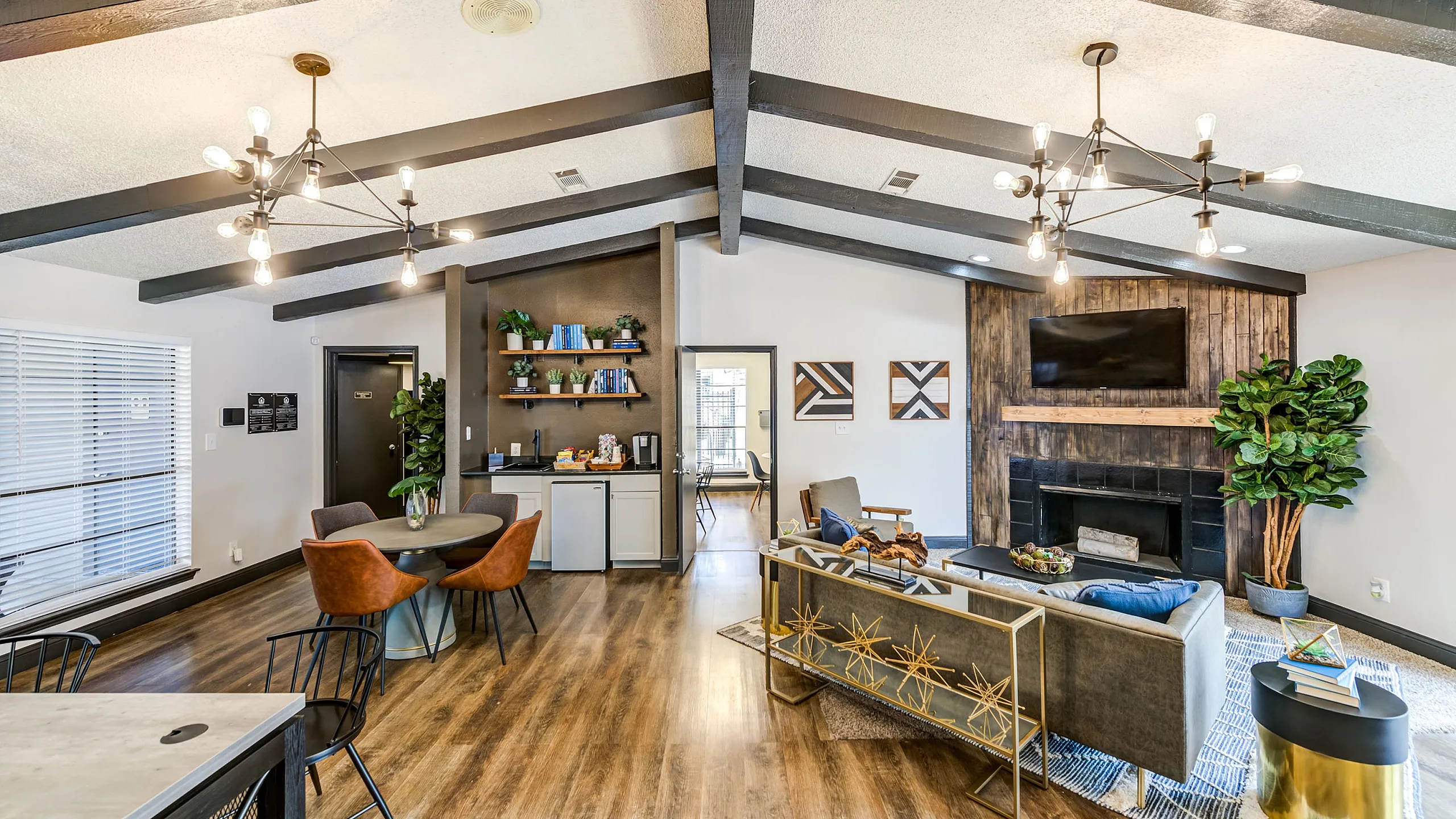 Chic open-concept living space featuring modern lighting, comfortable seating, and stylish decor with a cozy fireplace and elegant wood flooring.