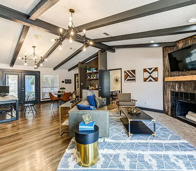 Chic open-concept living space with modern lighting, cozy seating, and a stylish fireplace, perfect for relaxation and entertainment.