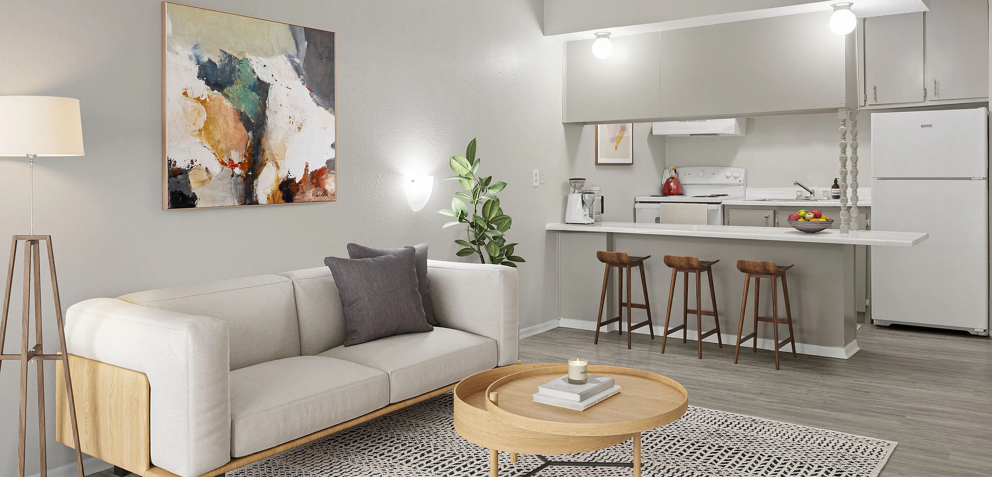 Chic open living space featuring a modern kitchen with bar seating, stylish artwork, and a cozy sofa in a bright ambiance.