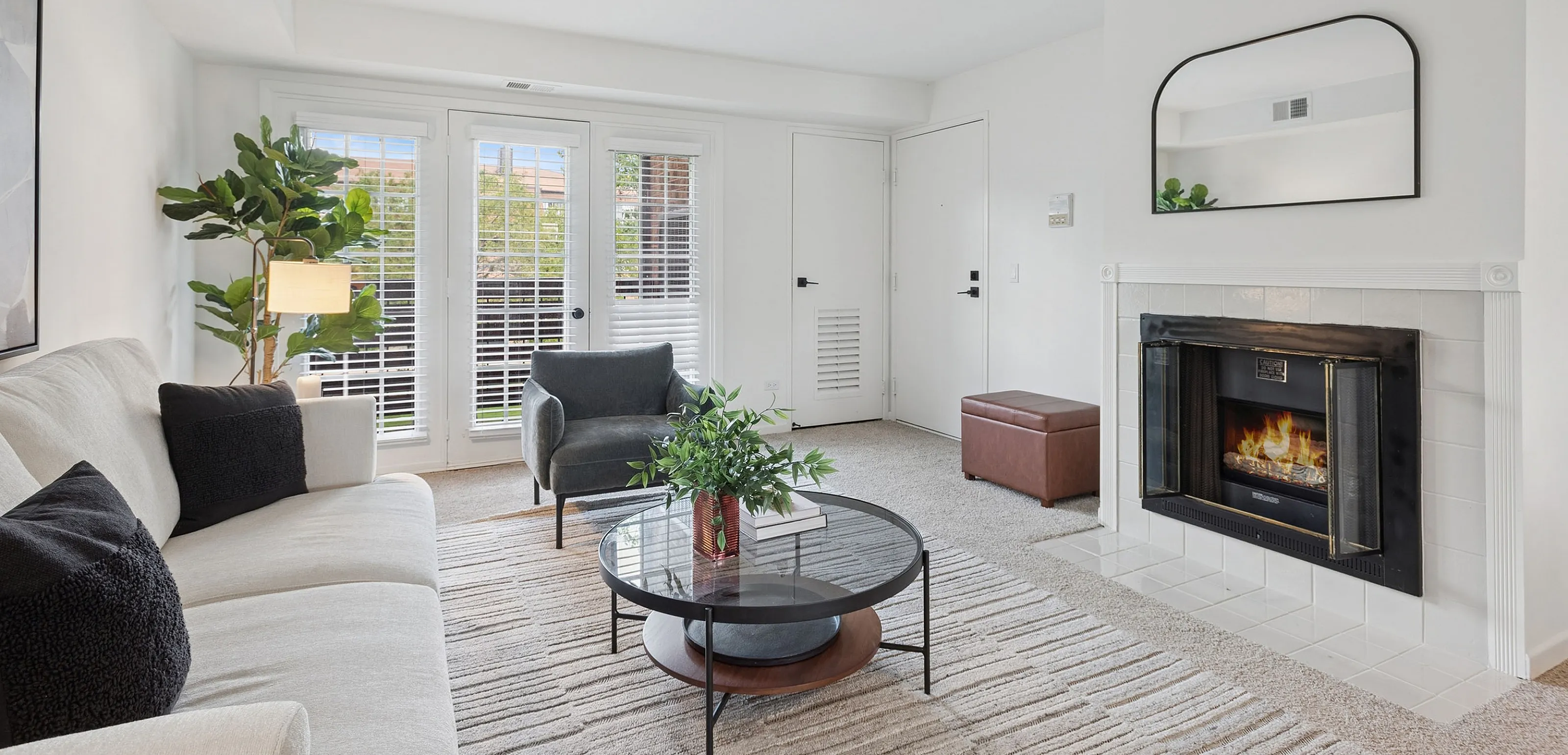Bright and inviting living room with modern decor, featuring a cozy fireplace, elegant furniture, and abundant natural light.