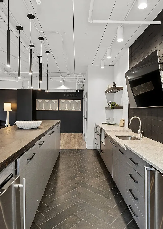 Contemporary open-concept kitchen with sleek countertops, modern lighting, and elegant shelving, perfect for entertaining.