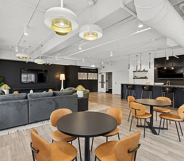 Modern open-concept living space with chic seating, contemporary lighting, and a sleek kitchen area, creating a stylish, welcoming environment.