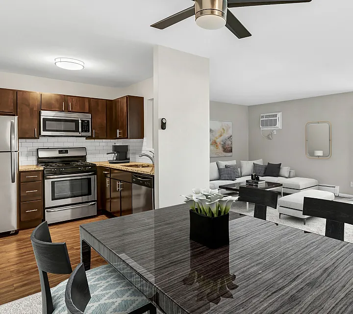 Modern open-concept apartment with sleek kitchen, stainless steel appliances, and a bright living area with cozy seating and balcony access.