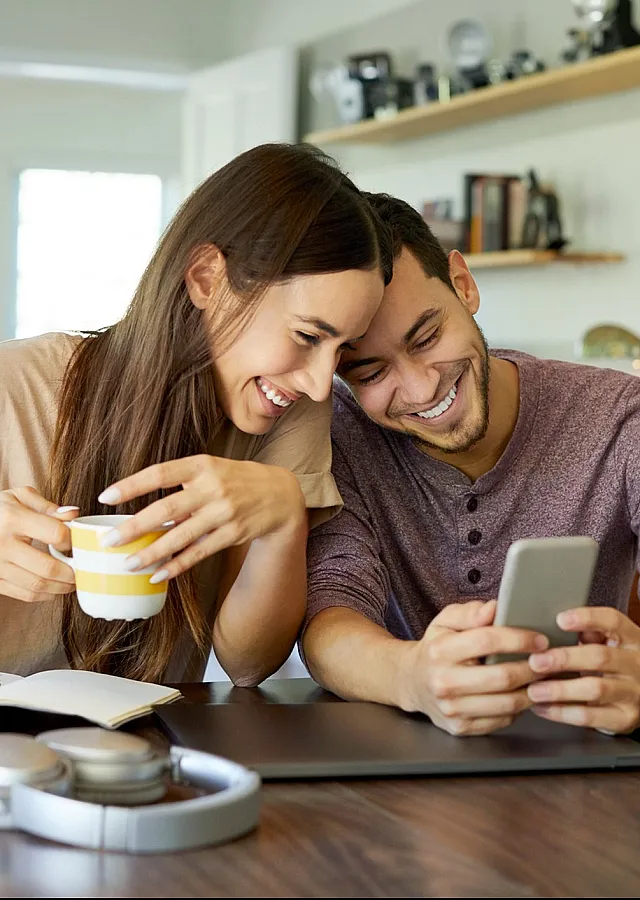 Happy couple enjoying a cozy moment in a modern dining area, featuring natural light and stylish decor.