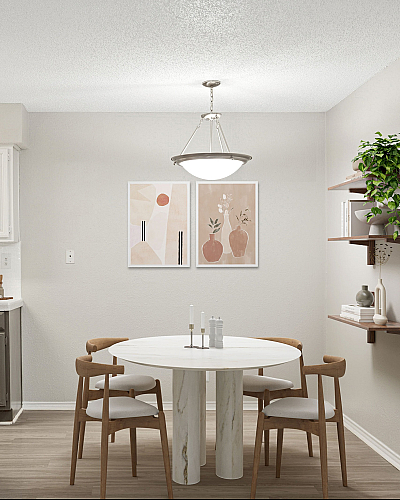 Elegant dining area at ReNew Holiday Hill with modern round marble table, wooden chairs, and artistic decor, highlighting a cozy and inviting atmosphere.