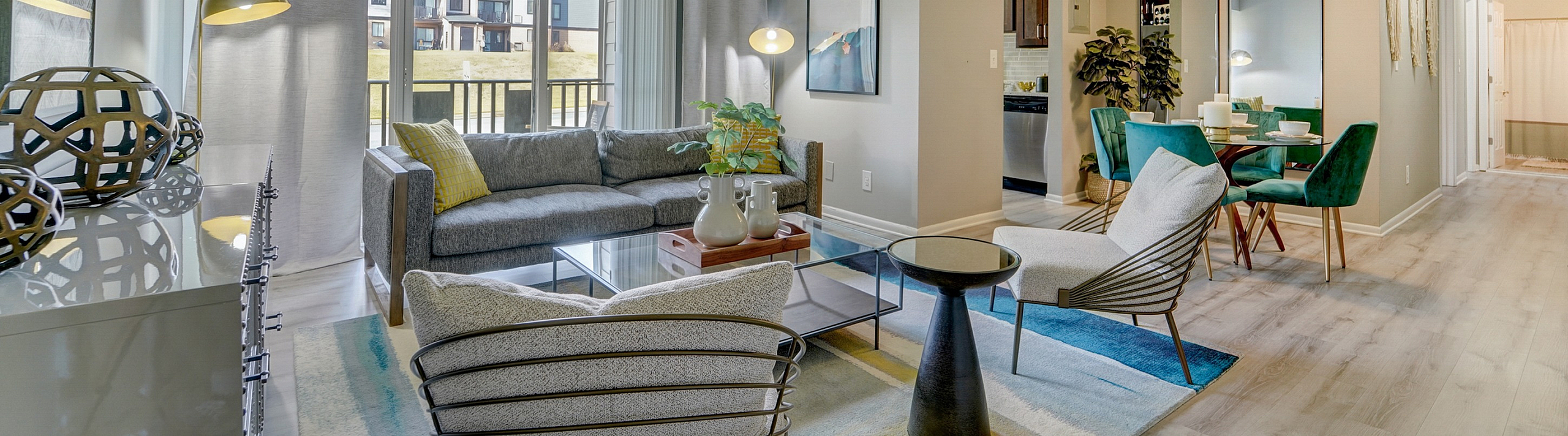 Bright and modern open-concept living room at ReNew White Marsh  with elegant furnishings and large windows offering beautiful outdoor views.