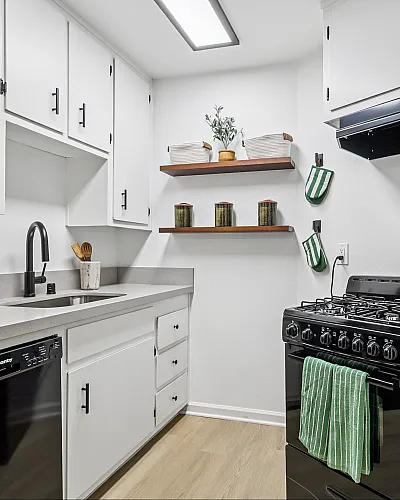 Bright, modern kitchen with sleek white cabinets, spacious countertops, and a stylish gas stove; perfect for culinary enthusiasts.