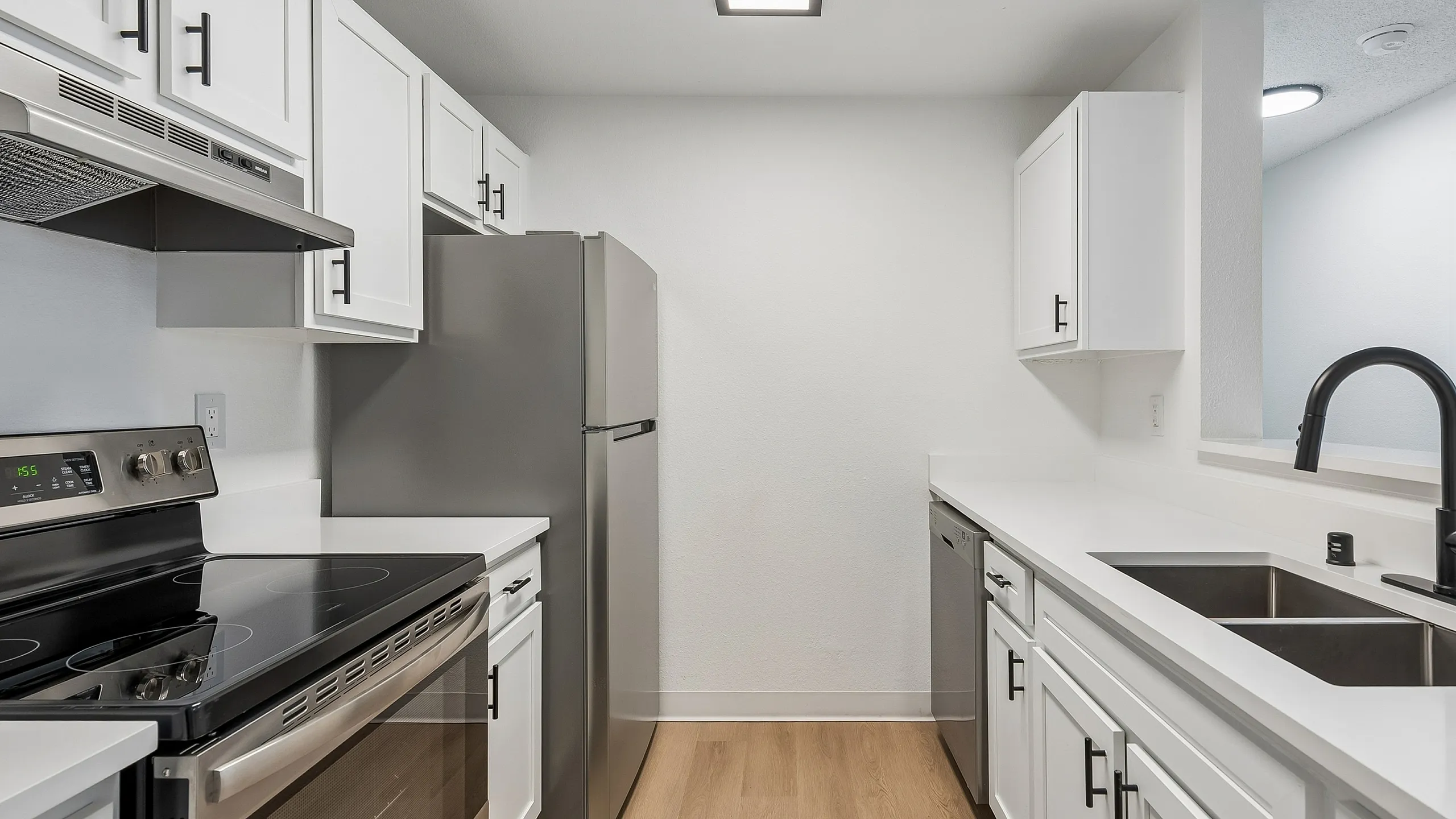 Modern kitchen with sleek stainless steel appliances, elegant white cabinetry, and a stylish black faucet offering a contemporary feel.