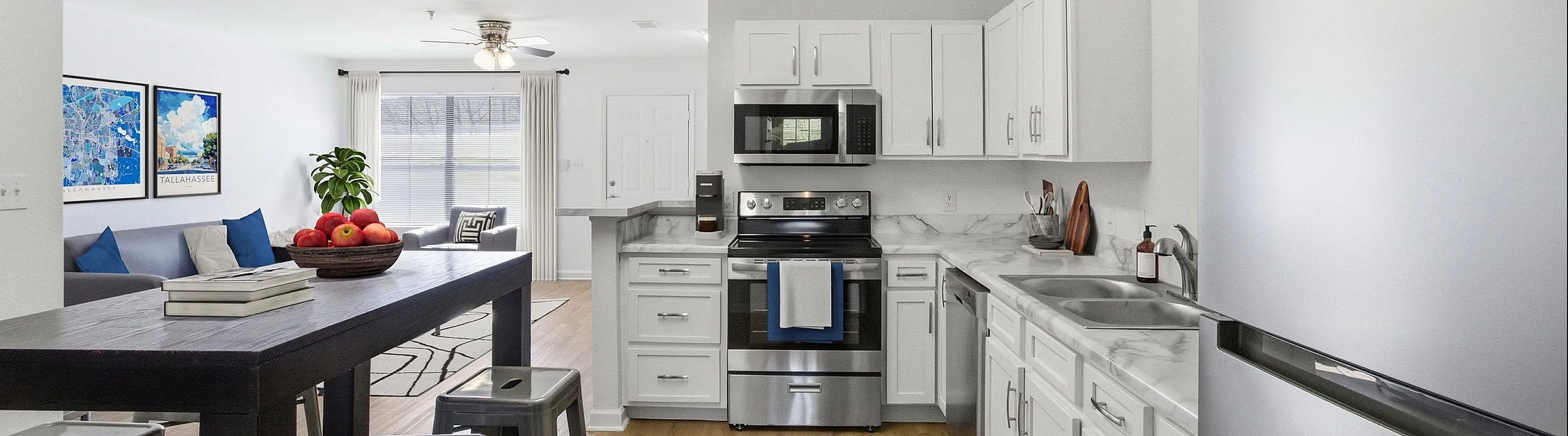 Modern open-concept kitchen with sleek white cabinets, stainless steel appliances, and an inviting dining area flowing into a cozy living space with natural light.