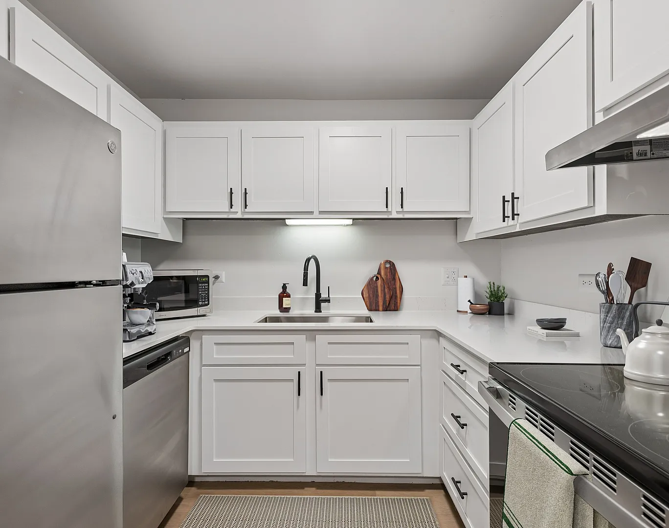 Modern kitchen with sleek white cabinetry, stainless steel appliances, and stylish countertops.