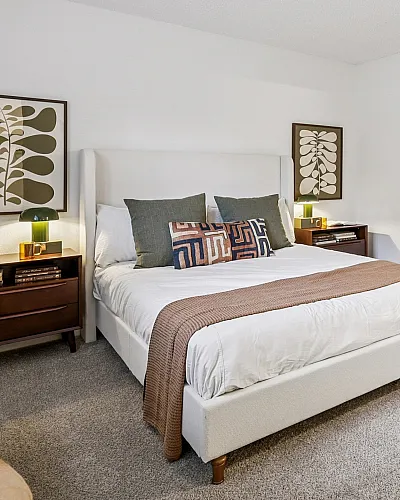 Elegant bedroom with modern decor, featuring a plush bed, stylish artwork, and warm lighting, perfect for a cozy retreat.