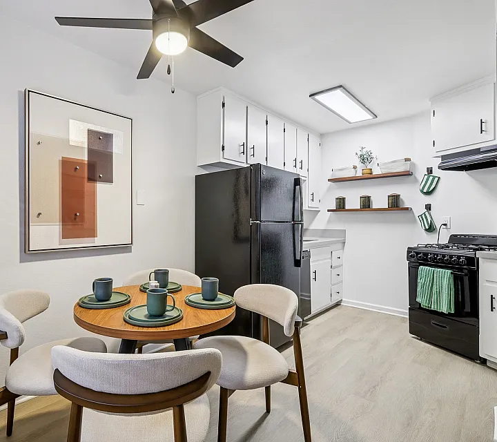 Chic dining area with stylish decor, modern kitchen appliances, and cozy seating for four, perfect for intimate gatherings.