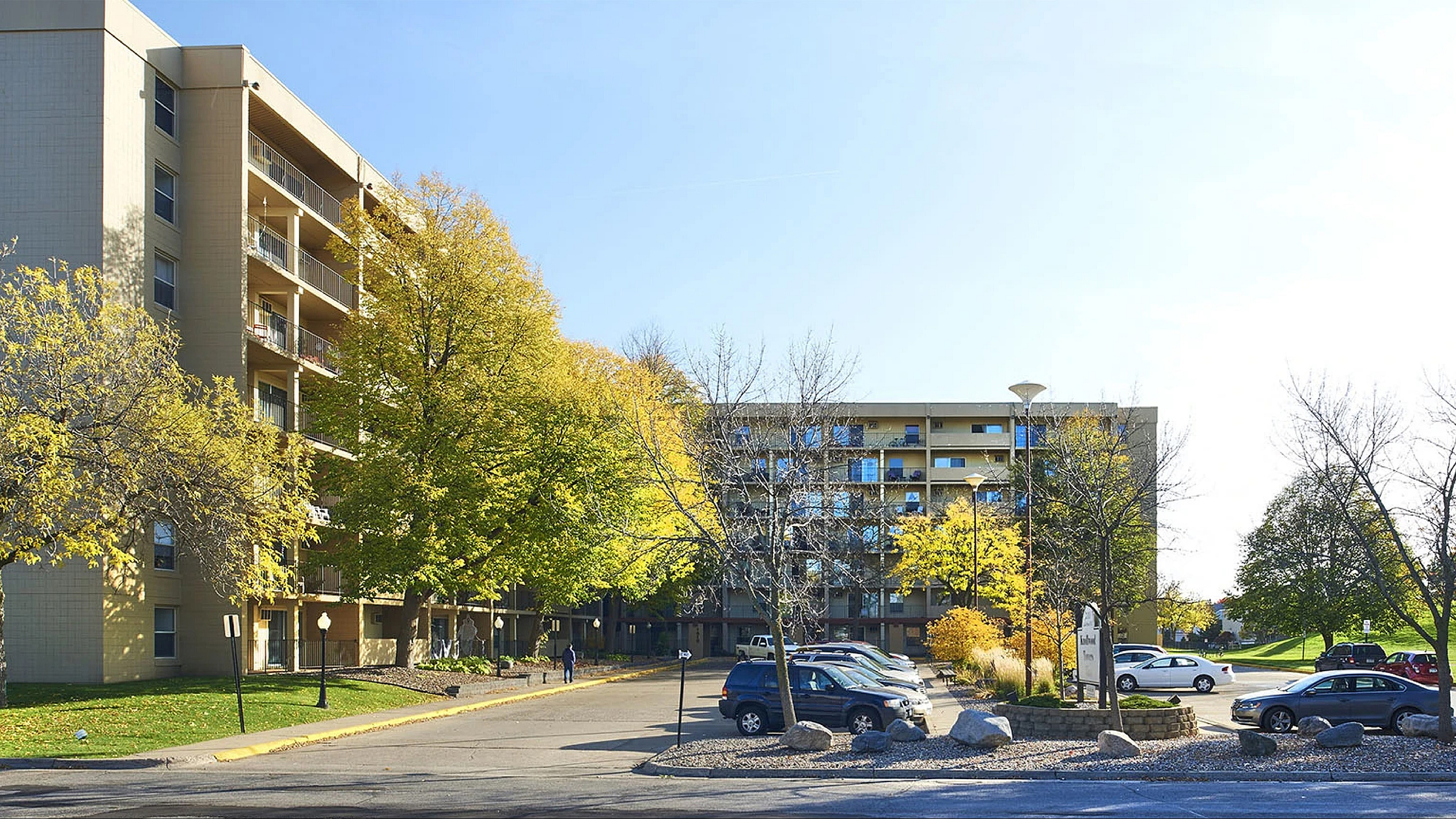 Charming apartment complex with lush greenery and ample parking, perfect for serene living.
