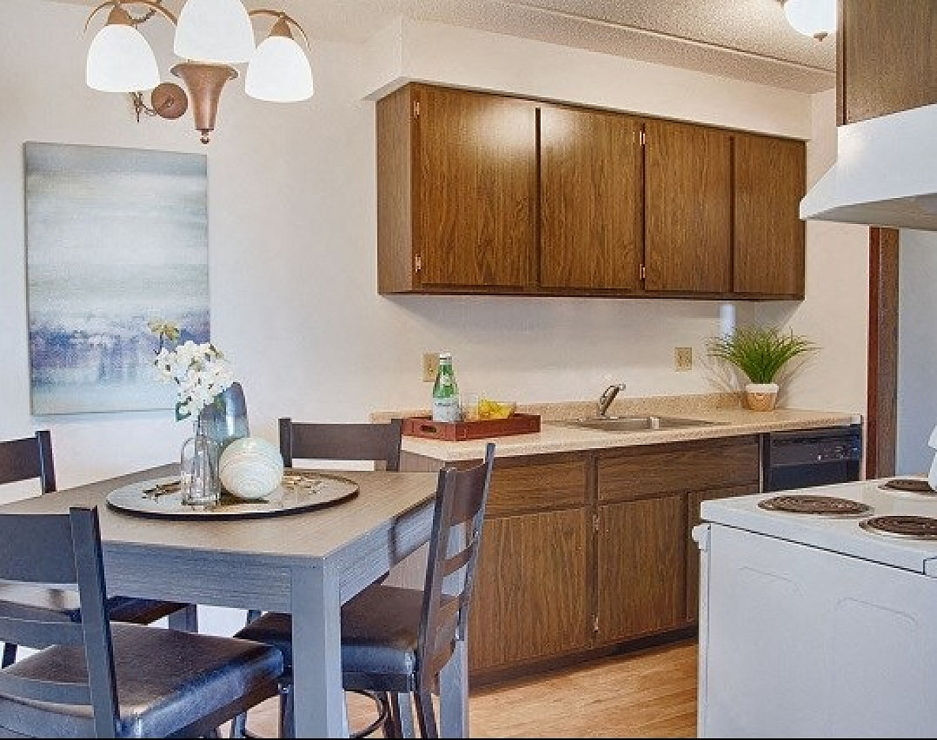 Charming kitchen with wooden cabinets, cozy dining area, and bright lighting creates a warm and inviting ambiance.