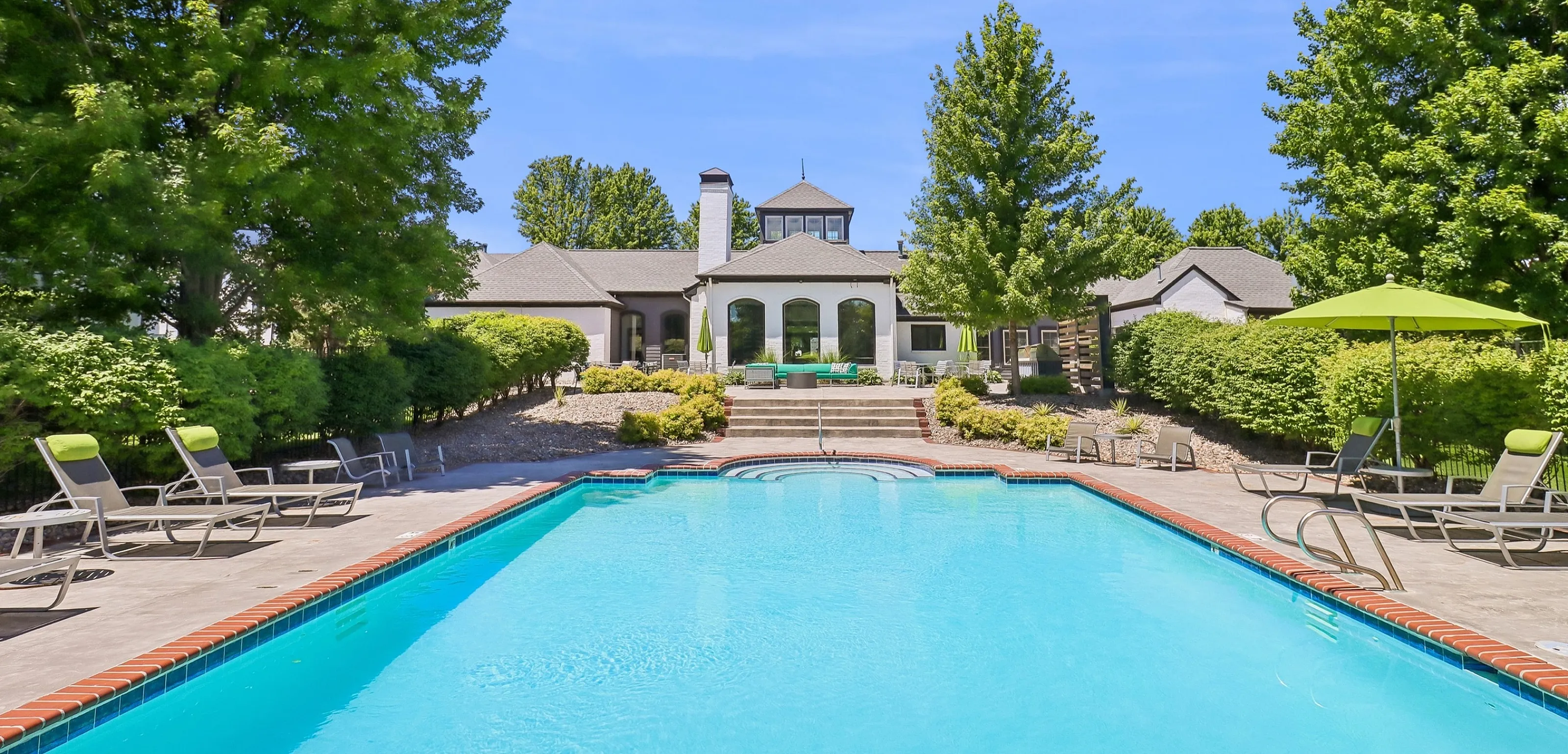 Luxurious swimming pool oasis surrounded by lush greenery and elegant architecture, perfect for relaxation and entertainment.