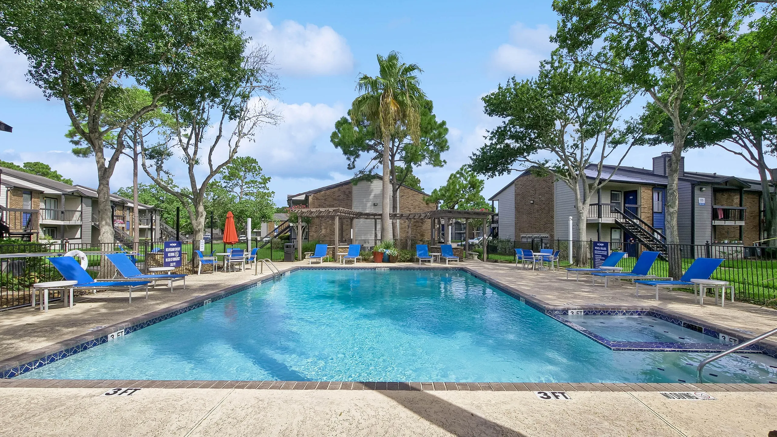 Inviting outdoor pool area with surrounding lounge chairs and lush greenery, perfect for relaxing and enjoying sunny days.