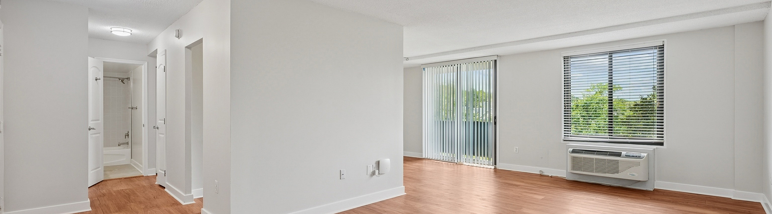 Bright and airy living space featuring elegant wood flooring, large windows, and modern lighting, perfect for comfortable living and relaxation.