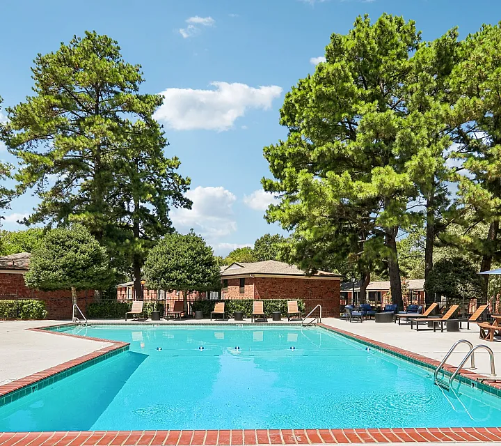 Inviting outdoor swimming pool surrounded by lush greenery and comfortable lounging areas, perfect for relaxation and leisure.