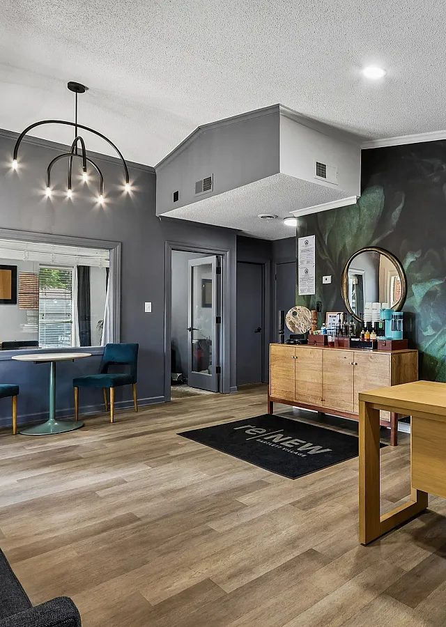 Modern office space with chic decor, featuring elegant lighting, a sleek wooden desk, and vibrant artwork.