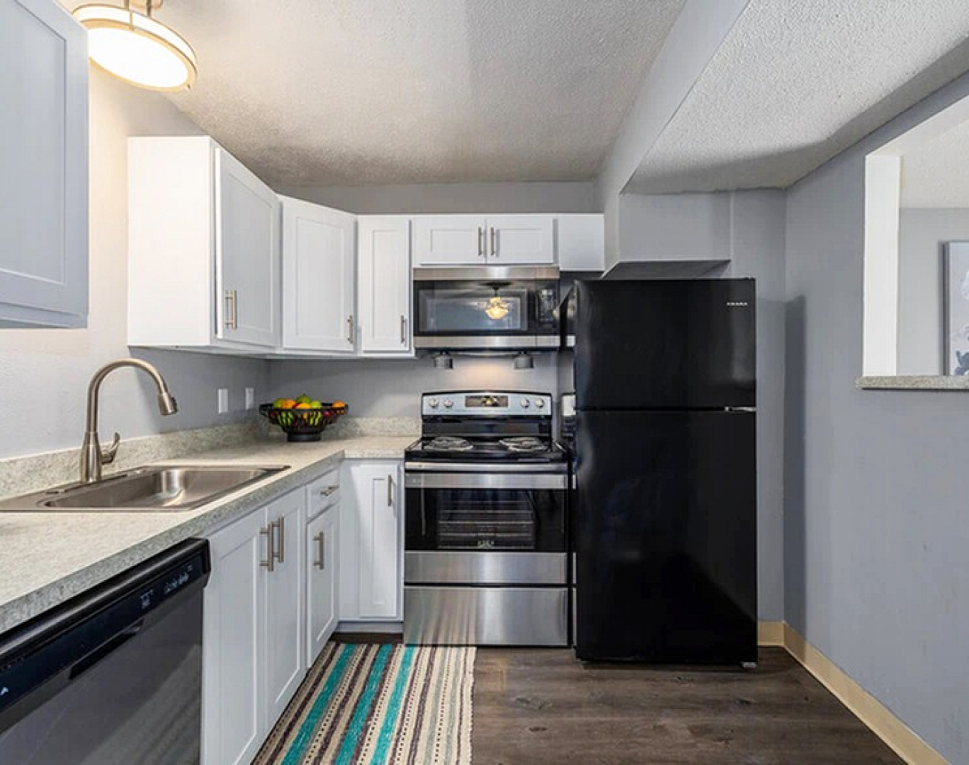 Modern kitchen with sleek black appliances, elegant white cabinetry, and stylish countertops, perfect for culinary enthusiasts.