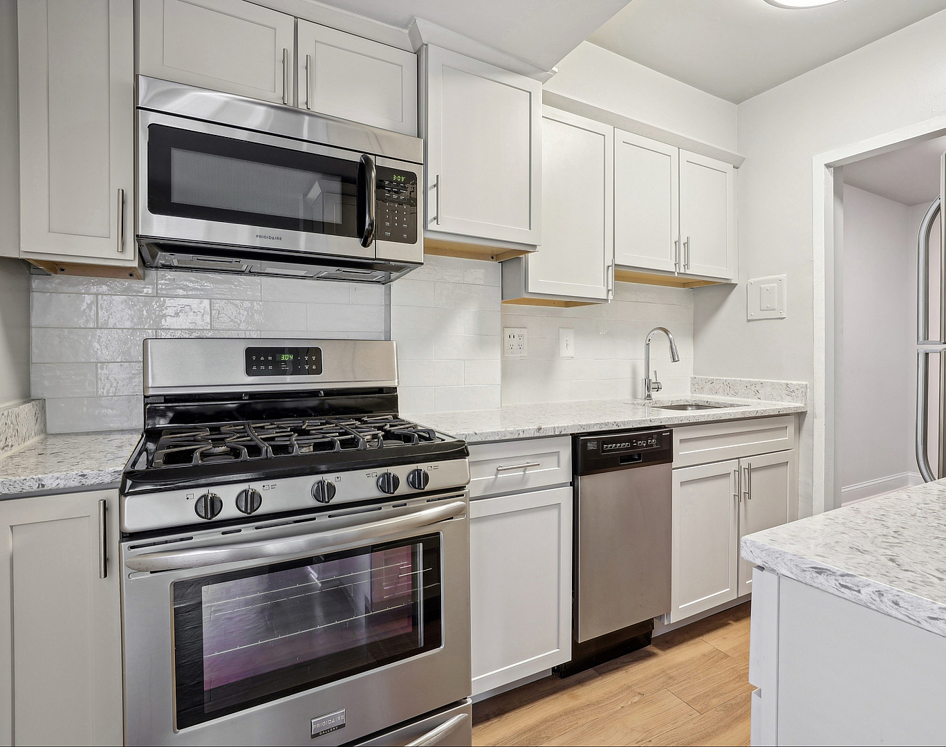 Modern kitchen featuring sleek stainless steel appliances, stylish white cabinetry, and elegant granite countertops.