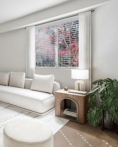 Elegant living room with a modern white sectional sofa, stylish coffee table, and large window overlooking lush greenery.