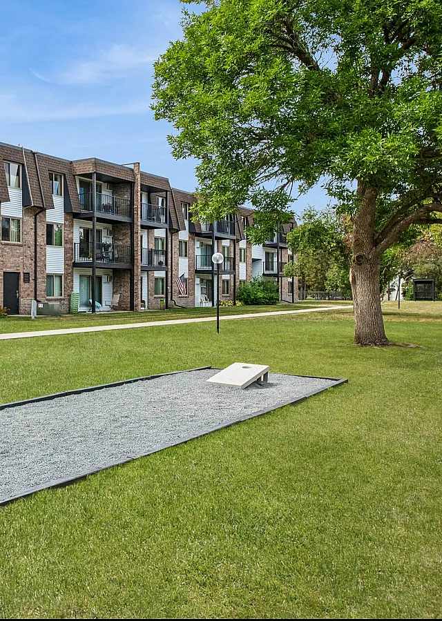 Inviting apartment complex featuring modern balconies and lush green open spaces, perfect for relaxation and outdoor activities.