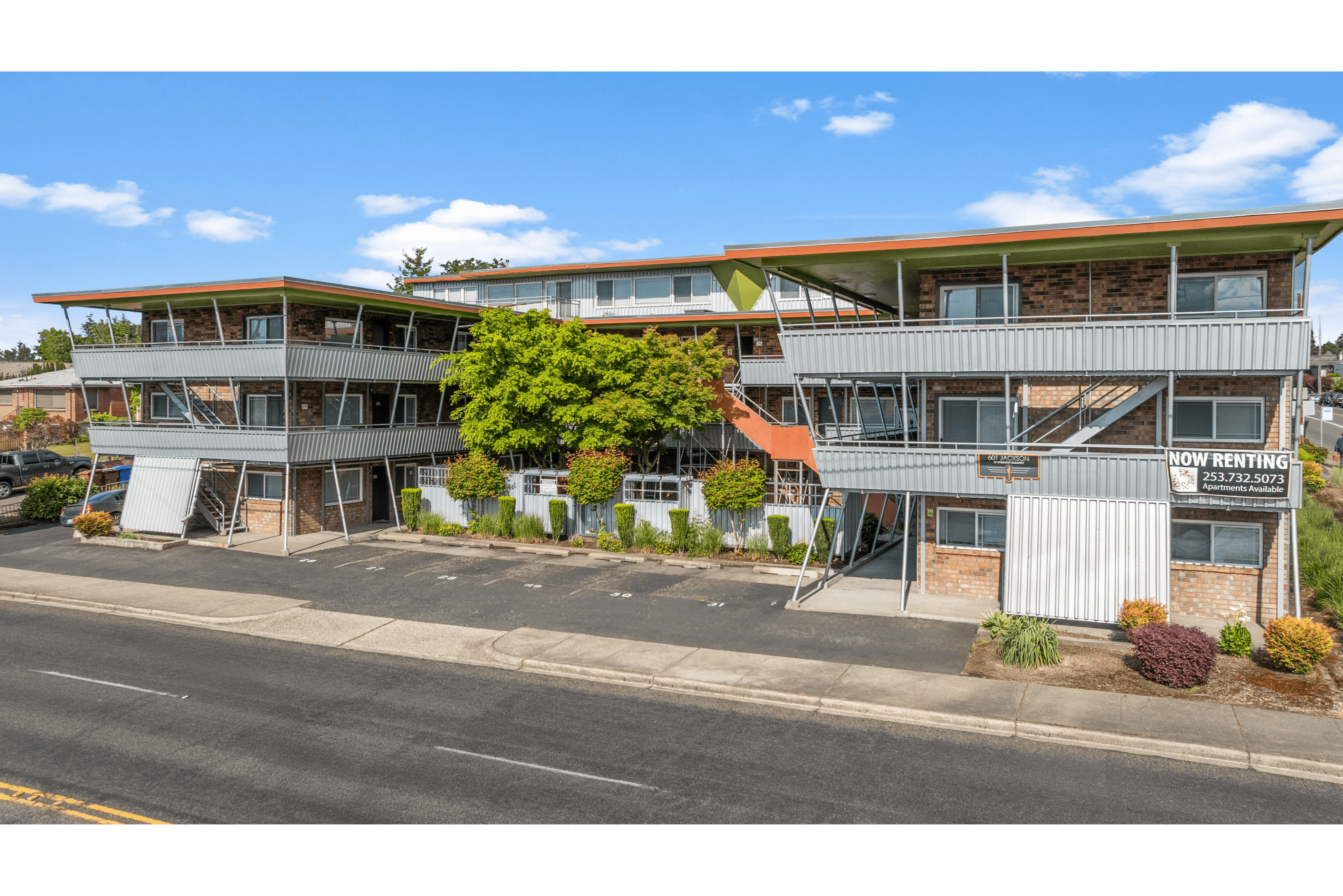 Contemporary apartment complex with modern architecture, ample parking, and lush greenery. Ideal for those seeking a vibrant and convenient living space.