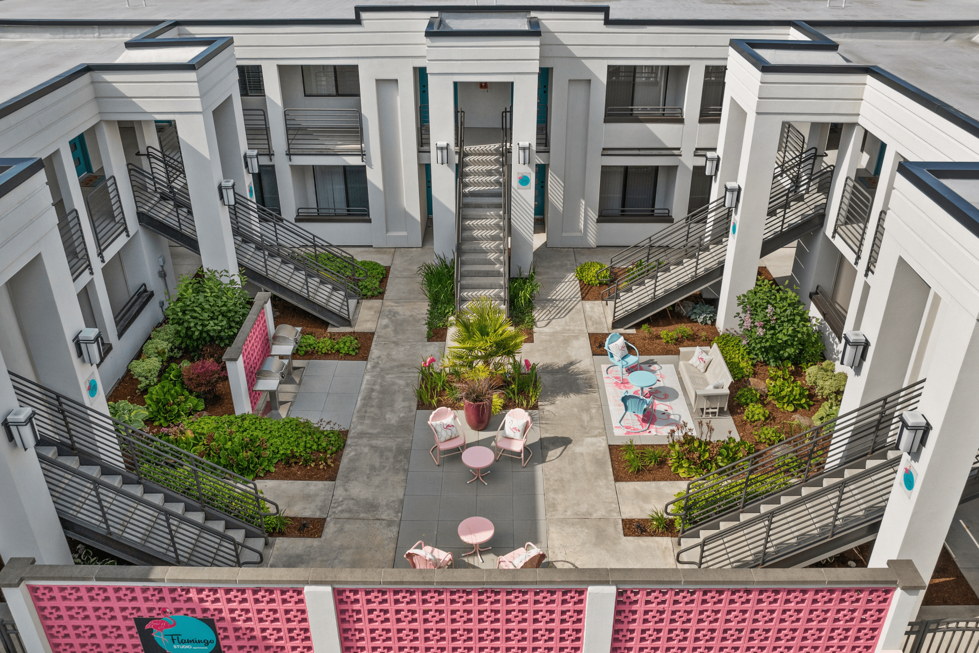 Charming apartment courtyard featuring stylish outdoor seating, lush greenery, and modern architecture, perfect for relaxation and community gatherings.