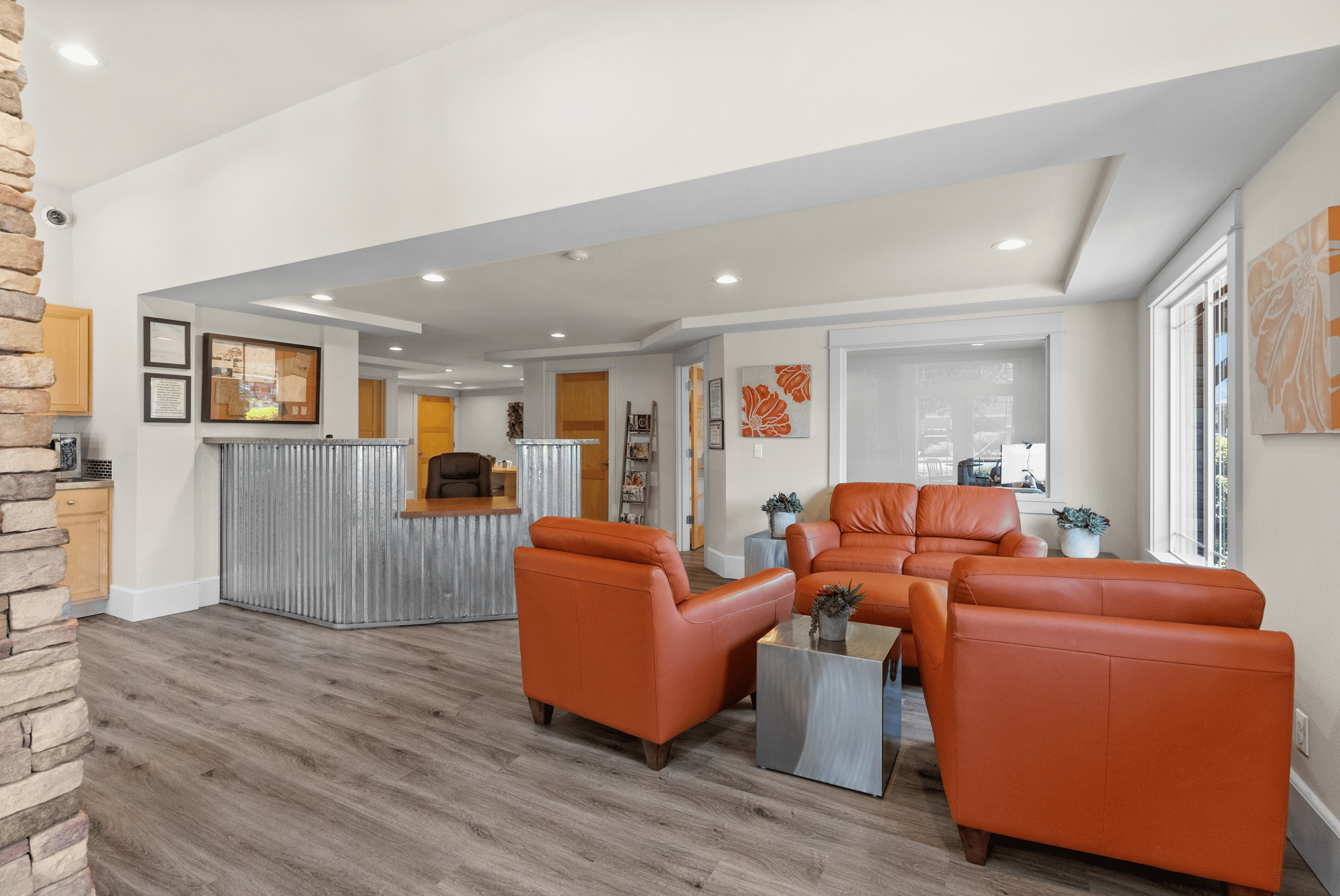 Modern lobby with vibrant orange leather seating, stylish wood flooring, and contemporary décor.