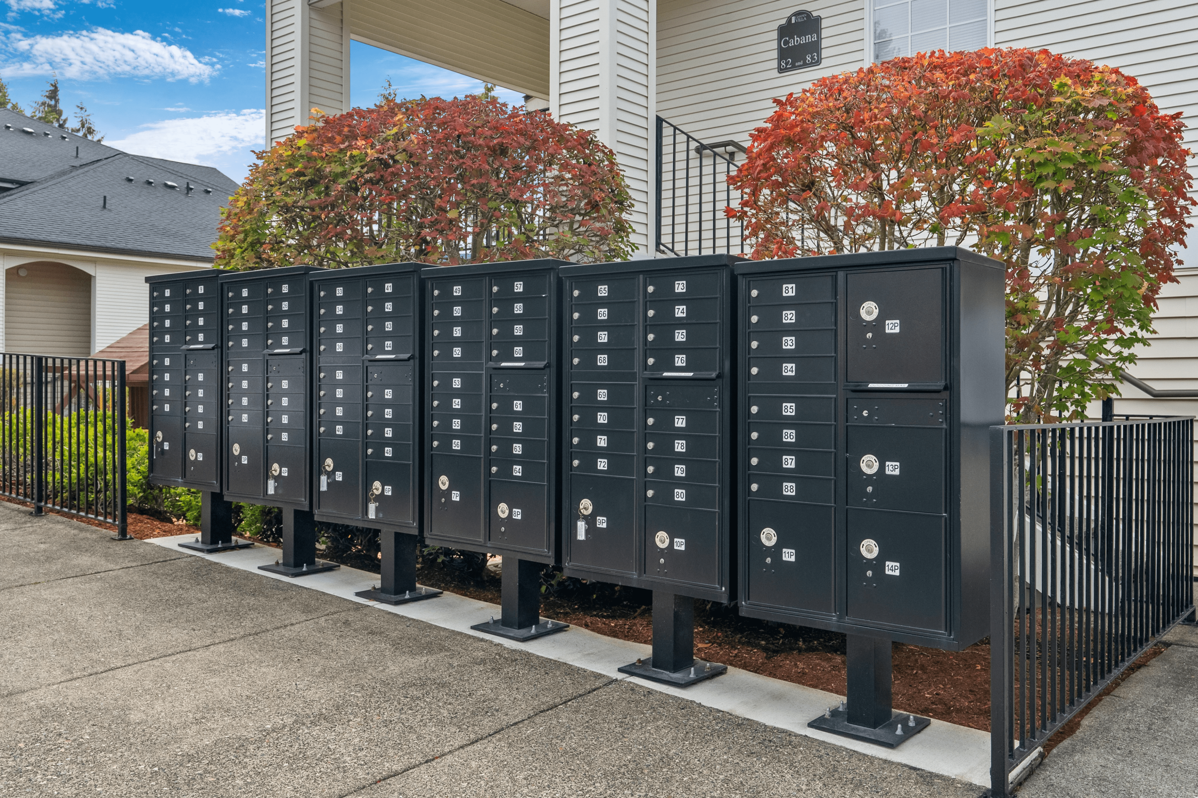 Modern apartment community mailboxes surrounded by lush greenery and vibrant shrubbery, enhancing curb appeal.