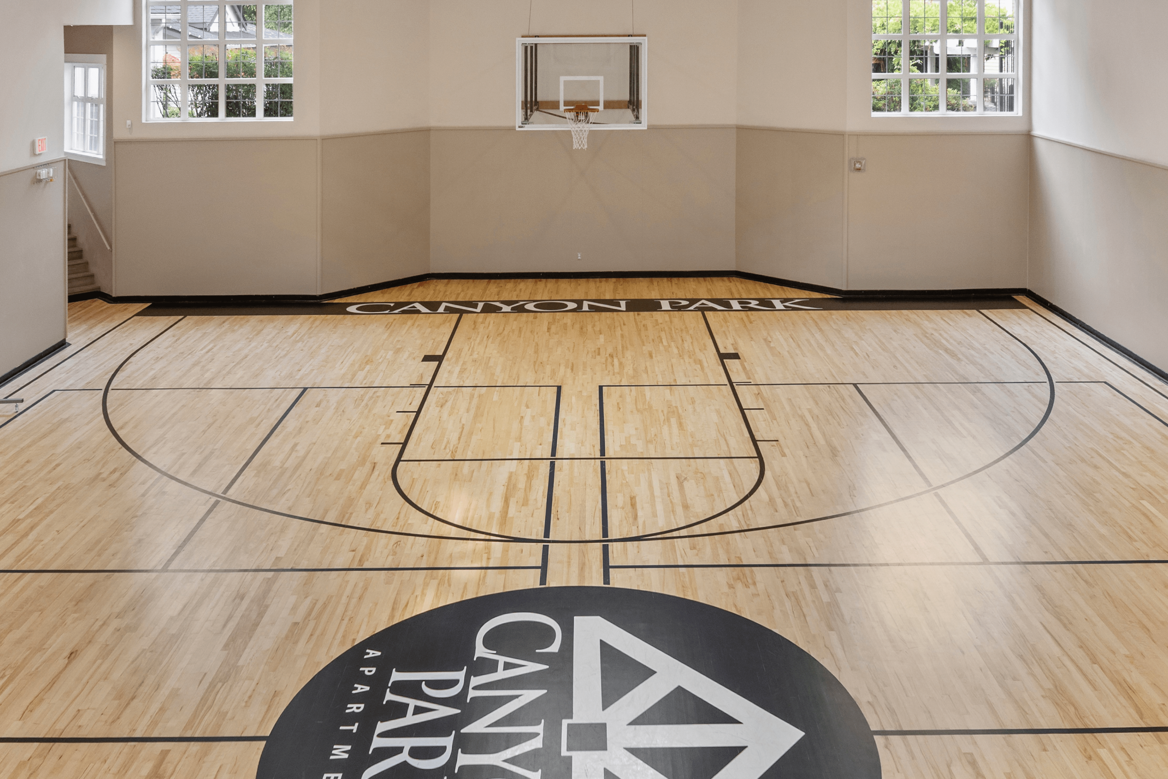 Luxurious indoor basketball court with polished wooden flooring and bright natural lighting at Canyon Park Apartments.